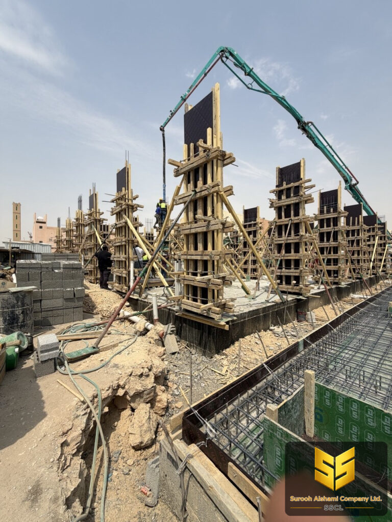 عمال ينفذون صب أعمدة خرسانية داخل الشدات الخشبية باستخدام مضخة خرسانة في الرياض