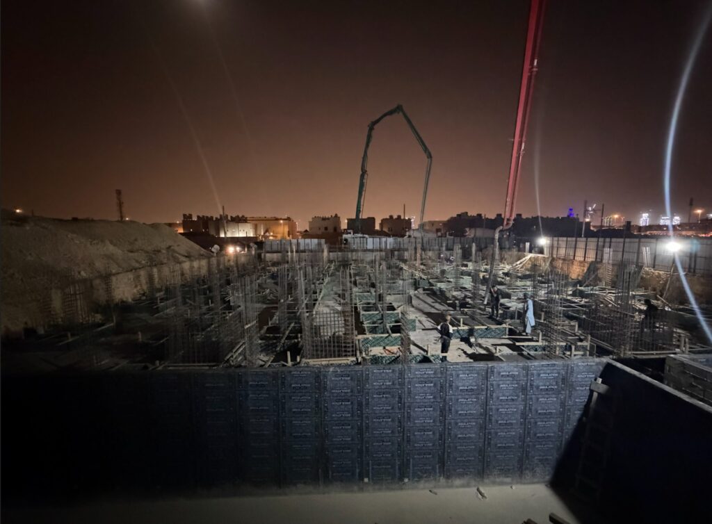 مضختا خرسانة بذراعين ممتدين فوق مشروع إنشائي أثناء تنفيذ الصب ليلًا في الرياض